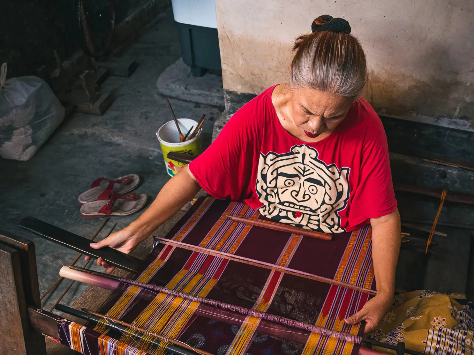 a woman makes a sarong in Tetebatu