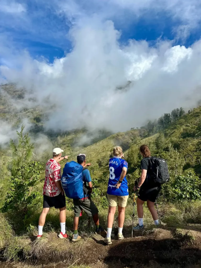 A friendly local guide explaining the route on a map to a group of happy trekkers.