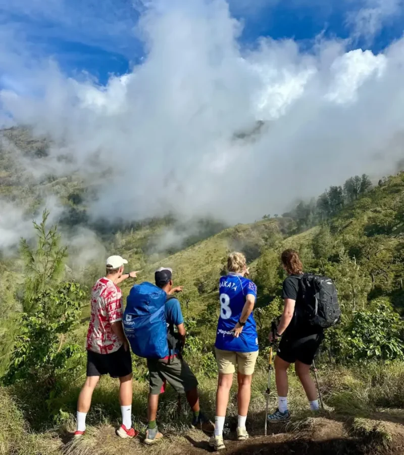 A friendly local guide explaining the route on a map to a group of happy trekkers.